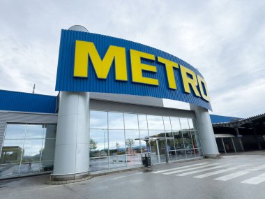 Bulutlu bir günde büyük tabelası olan modern metro süpermarketi..