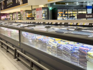 Süpermarkette dondurulmuş gıda reyonu, vitrinler ve çeşitli paketlenmiş ürünler.
