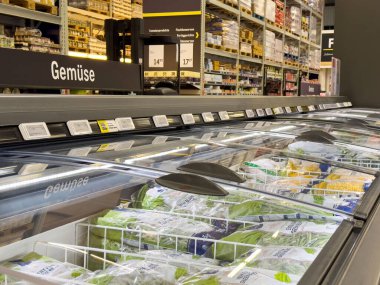 Süpermarketin dondurucusunda dondurulmuş ürünler ve koridorlu sebze bölümü..