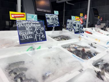 Fiyat etiketli taze deniz ürünleri ve bir markette buz..