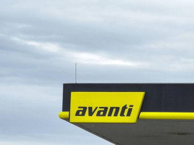 Bulutlu gökyüzüne karşı avanti logosu olan bir benzin istasyonu..