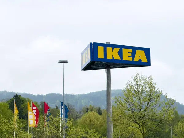 Manzaralı arka planda bayrakları olan büyük bir ikea mağaza tabelası.