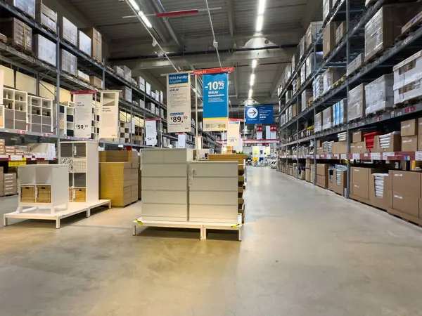 Ev ürünleri sergilenen raflar ve kutularla modern mobilya mağazası koridoru.