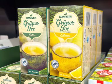 Perakende vitrininde doğal ve limon aromalı mayfair yeşil çay kutuları.