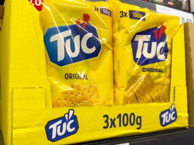 Rafta sergilenen parlak sarı ambalajlı Tuc orjinal krakerleri.