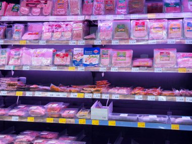 Raflarda paketlenmiş et ve et ürünleri olan süpermarket bölümü..
