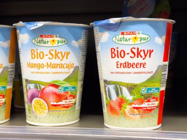Organik biyo-skyr mango-maracuja ve rafta çilekli yoğurt..