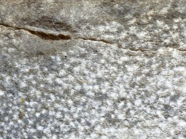 Doğal desenleri ve çatlakları olan pürüzlü granit bir doku..