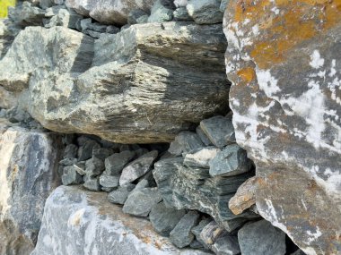 Çeşitli tonlar ve dokulara sahip pürüzlü taşların yakın plan görüntüsü.