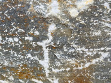 Doğal dokuları ve mineral renkleriyle yıpranmış kaya yüzeyine yakın çekim.