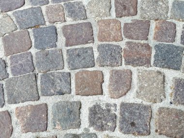 Yıpranmış taş bloklarla parke yol dokusuna yakın çekim.