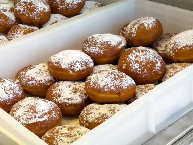 Lezzetli pudra jöleli çörekler beyaz plastik tepside.