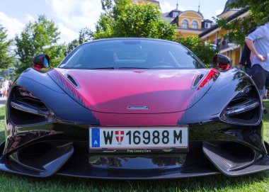 Velden, Avusturya - 22 Haziran 2024: Sportwagenfestival 'de sergilenen McLaren süperotomobili, zarif tasarımını ve canlı renklerini güzel bir arkaplana vurguluyor