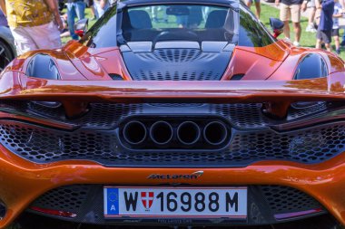 Velden, Avusturya - 22 Haziran 2024: Sportwagenfestival 'de sergilenen McLaren spor otomobili, canlı turuncu rengi ve karmaşık arka özellikleri ile parlak tasarımı sergilenmektedir.