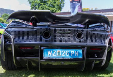 Velden, Avusturya - 22 Haziran 2024: McLaren süper arabası Sportwagenfestival 'de sergilendi, benzersiz arka tasarımı ve canlı yeşil çimen çevresi sergilendi