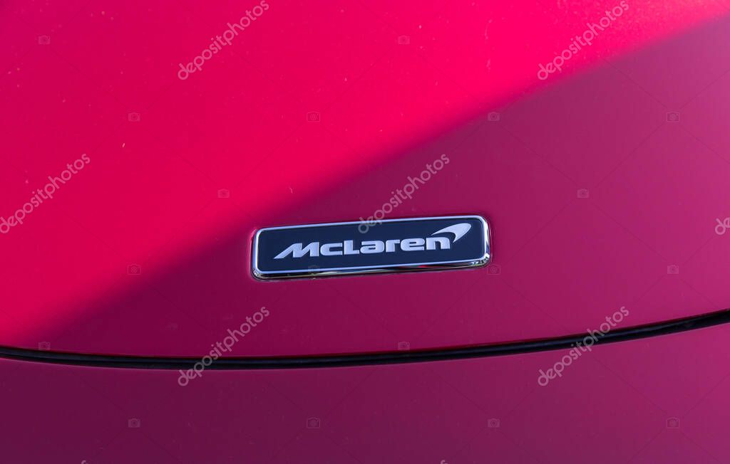 Velden, Austria - June 22, 2024: Close-up of McLaren emblem on red sports car at Sportwagenfestival, highlighting luxury and performance in automotive culture