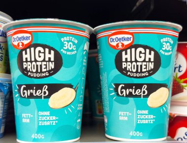 Villach, Avusturya - 06 Mayıs 2025: Dr. Oetker Yüksek Protein Pudingi bardakları lezzet etiketli canlı turkuaz ambalajlar sergiliyor, sağlığa odaklı tatlı severler için mükemmel