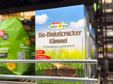 Villach, Avusturya - Mayıs 06, 2025: Spar Natur pur Bio-Dinkelcracker Kummel ambalajı süpermarket rafında parlak renklerle organik atıştırmalık seçenekleri vurguluyor