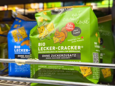 Villach, Avusturya - Mayıs 06, 2025: Nussy biyolojik vegan Lecker-Cracker atıştırmalık paketleri süpermarket raflarında canlı renkleri ve sağlık bilinci etiketlerini vurgulayarak düzenlenmiştir