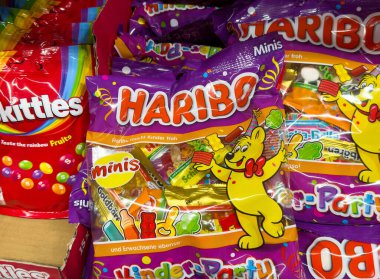 Villach, Avusturya - Mayıs 06, 2025: Şekerleme sergisi Haribo jelibon ayıları ve Skittles 'ı içeriyor, canlı bir perakende seti içinde hem çocuklara hem de yetişkinlere hitap ediyor