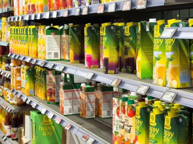 Villach, Avusturya - 06 Mayıs 2025: Süpermarket raflarında canlı renklerde meyve suyu kutuları düzenlenerek, perakende satış ortamındaki farklı lezzet ve markaları vurgulanıyor