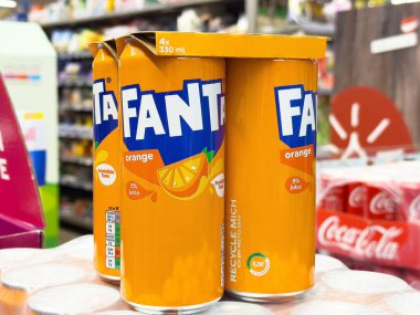 Villach, Avusturya - 06 Mayıs 2025: Fanta portakallı soda kutuları, canlı renkler ve canlandırıcı içecek seçenekleri vurgulanarak market koridorlarında belirgin bir şekilde sergilenmektedir