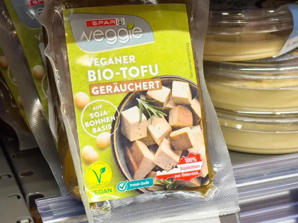Villach, Avusturya - Mayıs 06, 2025: Süpermarketin rafında sağlıklı yemek pişirmek için soya fasulyesi ve şifalı bitkilerle tütsülenmiş tofu küpleri bulunan SPAR vejetaryen biyo-tofu paketi