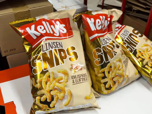 Villach, Avusturya - 06 Mayıs 2025: Kelly 'nin Linsen Snips torbaları bir masanın üzerine yerleştirilmiş, içerideki renkli ambalajlar ve çıtır çıtır atıştırmalıklar ön plana çıkarılıyor