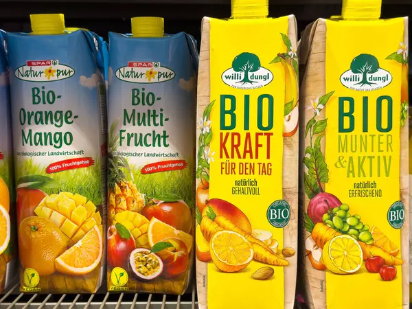Villach, Avusturya - Mayıs 06, 2025: Portakal-mango, çok meyveli organik meyve kartonları süpermarket raflarında harmanlanarak taze malzemeler ve canlı renkler vurgulanıyor
