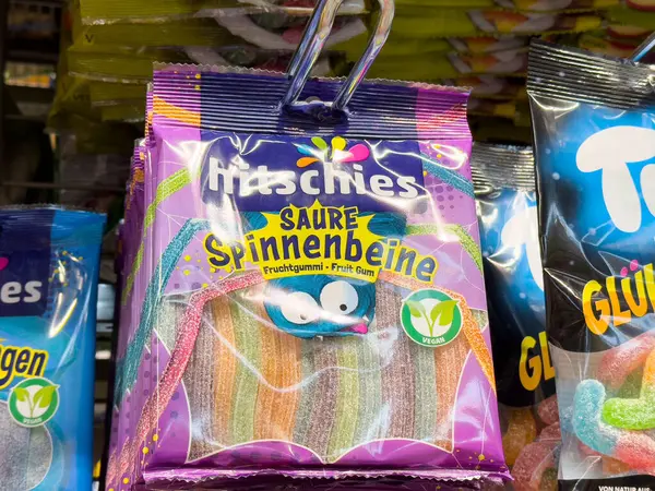 Villach, Avusturya - Mayıs 06, 2025: Hitschies ekşi sakızlı şeker paketi canlı gökkuşağı örümcek bacakları sergiliyor, tatlı için ideal.