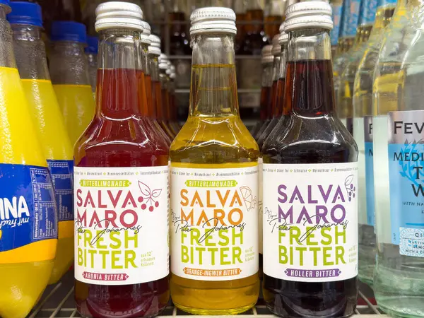 Villach, Avusturya - Mayıs 06, 2025: Üç renkli Salva Maro Fresh Bitter şişesi çeşitli içeceklerle bir rafa dizilir, eşsiz tatları ve sanatsal cazibeleri vurgulanır