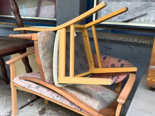 Dışardaki döşeme tezgahına istiflenmiş sandalyeler.