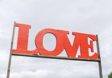 Bulutlu gökyüzüne karşı kırmızı aşk işareti.