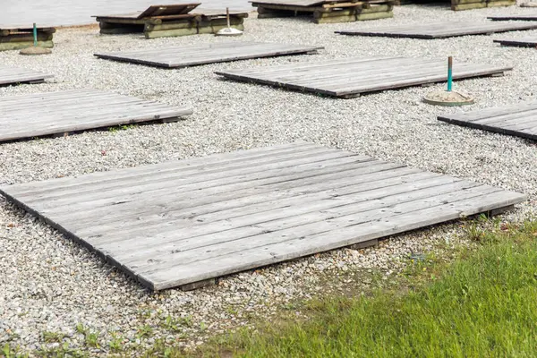 Göl kenarındaki çakıl tarlasında boş ahşap platformlar.