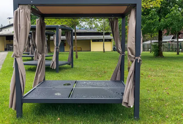 Açık hava parkında perdeleri olan otların üzerinde paraşüt yatakları..