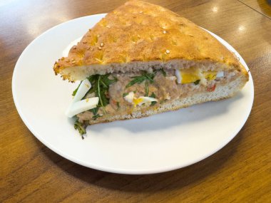 Yumurtalı ton balıklı sandviç ve beyaz tabakta Focaccia ekmeği..