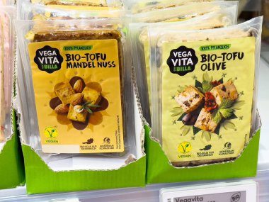 Çeşit çeşit vejetaryen tofu paketleri ve market vitrininde fındık ve zeytin çeşitleri..