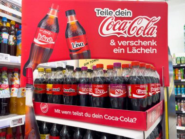 Coca-Cola şişelerinde kişiselleştirilmiş Alman isimleriyle bir kola sergisini paylaşın.