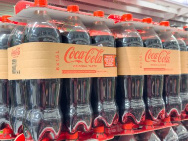 Rafta duran Coca-Cola şişelerinde altı paket klasik meşrubat sergileniyor..