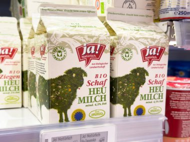 Rafta organik koyun saman süt kutuları sergileniyor.