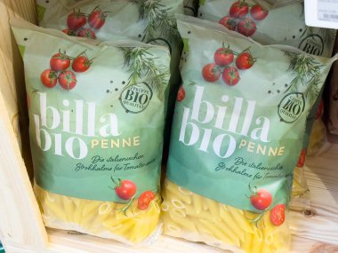 Çeri domatesli ve ahşap rafta bitki ambalajlı organik billa biyo penne makarna..