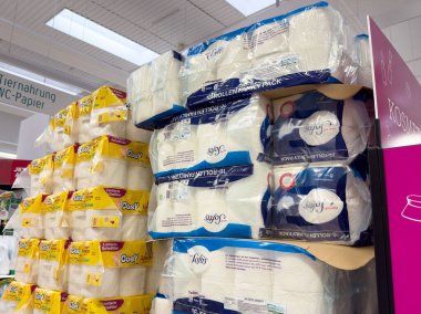 Parlak ambalajlı kağıt ürünleri depolama koridorunda sergileniyor.