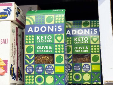 Raflarda zeytin ve chia tohumları olan Adonis keto krakerleri..