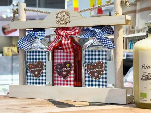 Tahta taşıyıcı ekranda kalp etiketli Bavyera temalı şişeler.