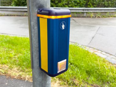 Şehir caddesinde çimenli ve kaldırımlı modern yaya geçidi düğmesi.