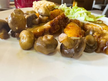 Beyaz tabakta mantar ve lahana ve pilav ile kızarmış tavuk..