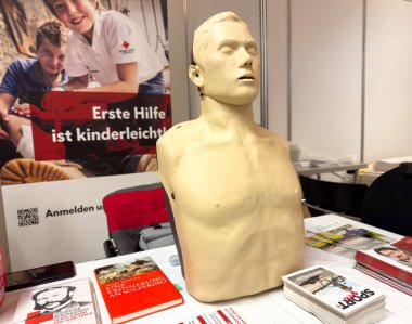 İlk yardım kabininde eğitim materyalleriyle CPR eğitim mankeni görüntüsü.