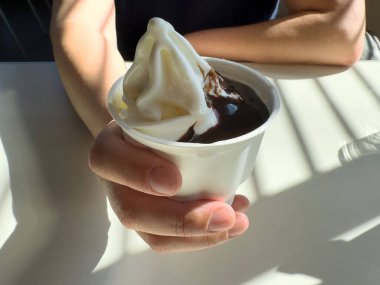 Beyaz erkek, çikolata soslu dondurma servisinin tadını çıkarıyor..