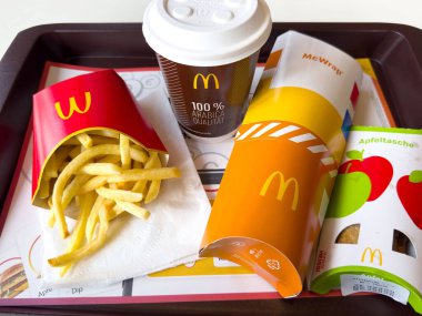 Fast food tepsisi patates kızartması, mcwrap, elmalı turta ve restoranda kahve fincanı..