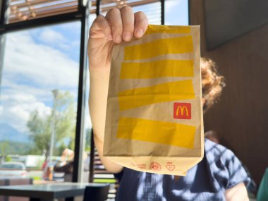 McDonald 'ın çantasının içinde güneşli restoran içinde bir kadın var..